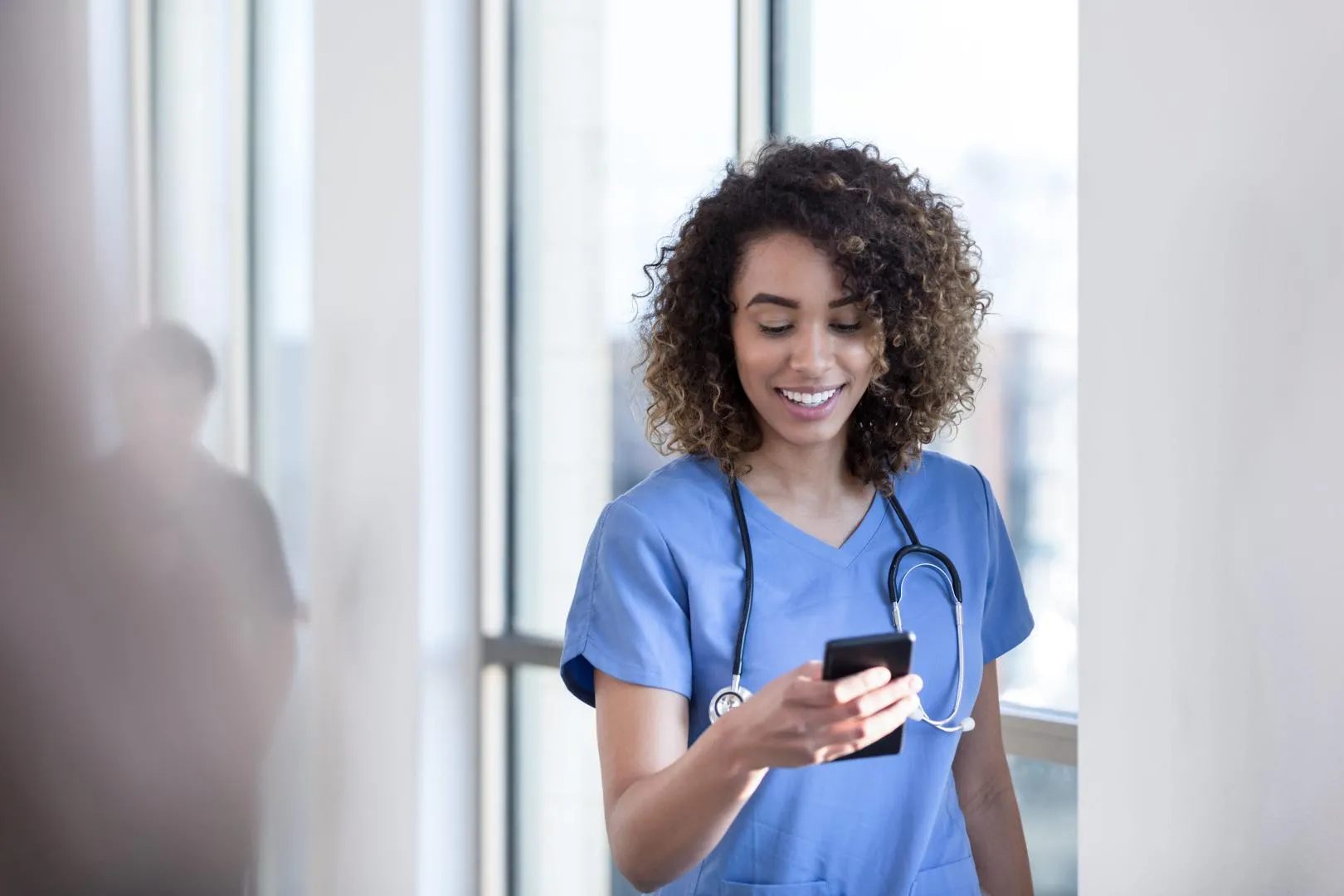 Frau mit Smartphone Klinikalltag Digital